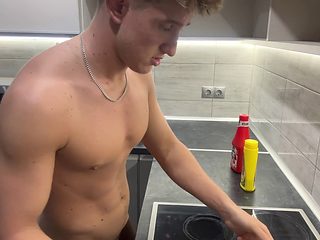 Handsome blonde guy prepares a delicious naked feast in...