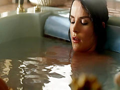 Crystal Allen reclining in the arms of Ana Alexander in a bath tub, her right nipple just barely coming into view above the water. From Femme Fatales.
