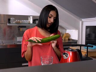A cute girl peels a cucumber for her older man in a sen...